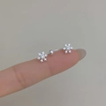 Zilveren sneeuwvlok navelpiercing met zirkonia vastgehouden op vingers - Zilveren Sneeuwvlok Stijl (C306)