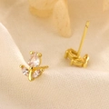 Exquises boucles d'oreilles tulipes dorées avec zircons brillants en perspective macro - Doré