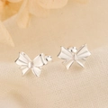 Stereo bow knot stud earrings in S925 silver on light beige fabric background - Bowknot Style (C243)