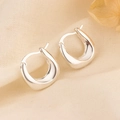 Orecchini a cerchio a U in argento lucido su sfondo di lino beige raffinato - Orecchini Huggie a forma di U lucidi color argento (HL-105)