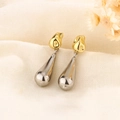 Elegantes pendientes colgantes bicolor oro y plata sobre un fondo de tela con textura - Estilo de Gota de Agua Oro y Plata (C287)