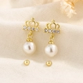 Gouden kroon oorbellen met witte parels en strass steentjes op beige linnen - Goud