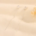 Pendientes de nudo plateados con borlas largas sobre tela beige y flores secas - Línea de Oreja con Nudo Ruyi (A231)