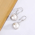 Elegant white pearl drop earrings with silver hooks and zircon accents on aesthetic background - White Gold