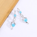 Silver wavy drop earrings featuring blue round gemstones in a sleek ribbon design - Sky Blue Zirconia (XP34)