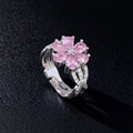 Edler Silberring mit rosa Zirkon-Kirschblüte auf schwarzem Lederhintergrund-Textur - Silber Rosa - Kleine Blume Ring