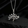 Macro del ciondolo albero della vita in argento con zirconi su una superficie di pietra - Stile Z Argento