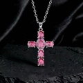Dettaglio della collana a croce con gemme rosa ovali su fondo di roccia nera ruvida - Stile G Argento Rosso