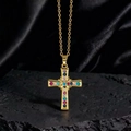 Dettaglio ciondolo a croce dorata con zirconi colorati su tessuto di seta nera - Stile K1 Oro Multicolore