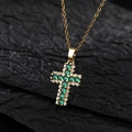 Elegante collar de cruz de oro con esmeralda y diamantes sobre fondo negro texturizado - Estilo D2 Cobre Chapado En Oro