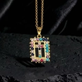 Dettaglio della collana dorata con pendente a croce in zirconi colorati su pietra nera - Stile W1 Oro Multicolore