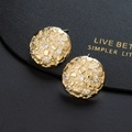 Close-up of golden lava texture stud earrings with zircon inlay on black leather - Golden Lava Texture Stud Style(B)