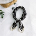 Classic black and white polka dot silk square scarf styled with a knot on a textured surface - Black Fine Spotted