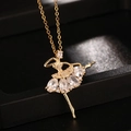 Dettaglio macro di un ciondolo ballerina dorato con pietre di zirconia scintillanti - Bianco (E)
