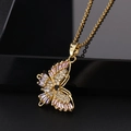 Gros plan détaillé d'un pendentif papillon doré avec des pierres de zircone roses et blanches - Papillon rose blanc et noir (I)