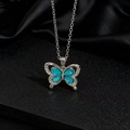 Détail du pendentif papillon argenté avec quatre pierres en zircon bleu clair serties - Papillon en argent avec gemme bleu clair (Z)