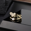 Double-layered gold ring with heart crystal and white pearl on minimalist black display - Pavé Heart Pearl Style (Y)