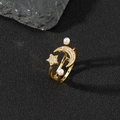 Detail of gold star and moon ring with pavé stones and dual pearls on dark stone - Vintage Star Moon Pearl Style (N)