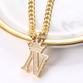 Détail du pendentif couronne lettre N dorée serti de zircons sur une chaîne cubaine - Lettre N