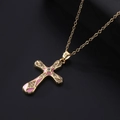 Macro detail of gold-plated cross pendant with pink enamel and white zircon inlay - Pink