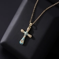 Close-up of a gold cross pendant with blue enamel and micro-pave cubic zirconia crystals - Light Blue