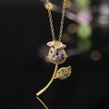 Macro view of a gold rose pendant necklace with colorful cubic zirconia on black background - Colorful Rose Style (A)