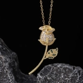 Macro shot of gold rose pendant with sparkling white zircons and green stone leaves - White Pave Rose Style (B)