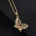 Collier papillon doré avec zircons colorés sur un fond noir texturé élégant - Papillon coloré avec pierre centrale bleu foncé (O)