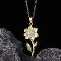 Macro shot of gold flower pendant with white zircons on dark stone background - Gold Sunflower White Zirconia Style (I)