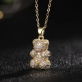 Vista macro de un collar con colgante de oso dorado con piedras de circón brillante - Estilo Q (Oso Oro Pavé Mínimo)
