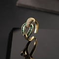Close-up of gold-plated open ring with green stones and pavé diamonds on black mirror - Geometric Hollow Rectangular Green Zircon Style