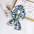 Elegant silk-like scarf with blue and green leaf pattern tied in a bow on a gold frame - Heart Leaf Green