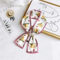 Floral silk twilly scarf with orange citrus print and purple trim knotted for style - Pear Pink