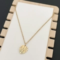 Collana con ciondolo a foglia di monstera dorata a specchio su supporto bianco - Oro