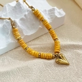 Bohemian necklace featuring yellow disc beads and a gold heart pendant on white stone - Yellow Heart Style