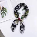 Floral and leopard print silk scarf styled as a necktie on a clean minimalist background - Spotted Black