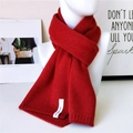 Roter Strickschal mit weicher Rippstruktur und minimalistischem Etikett am Rand - Kristall-Label Rot