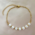 Elegantes vergoldetes Perlenarmband mit gedrehter Kette und sieben weißen Perlen - Goldperlen-Stil