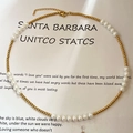 Collana di perle francese con sfere dorate e ciondolo a cuore su sfondo bianco - Collana di Perle in Acciaio al Titanio