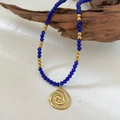 Handmade beaded necklace with blue stones and a gold spiral pendant on driftwood - Royal Blue Beaded Spiral Pendant Necklace