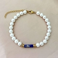 Elegante pulsera de perlas con piedra azul estampada y cierre de langosta dorado - Estilo de Piedra con Textura Azul Oscuro