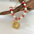 Handgemaakte ketting met rode koraalstukjes, parels en gouden bloemhanger op hout - Parel Steenslag Bloem Ketting