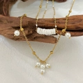 Double-layered golden stainless steel necklace with baroque pearls on a rustic wood branch - Pearl Shell Double Layer Necklace