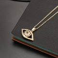 Collar de Ojo Turco dorado con circonitas azules y blancas sobre fondo negro - Mal de Ojo Ovalado Pavé Circonia (M)