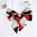 Macro detail of silk-feel skinny scarf with multi-color geometric patterns and care label - Red Umbrella
