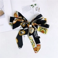 Detail of a large black bow hair clip featuring playing card and sun prints on silk fabric - Heart Label Black