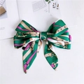 Close-up of green satin skinny scarf tied in a bow with floral patterns and washing label - Thin Belt Chain Green