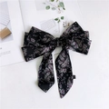 Detail of black satin hair bow with paisley floral pattern on magazine background - Black Paisley