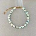 Elegantes Perlenarmband mit blauen Marmorsteinen und Goldperlen auf grauem Hintergrund - Blau