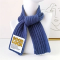 Blue knit scarf with white Good Luck letter patch on a white mannequin display - Blue